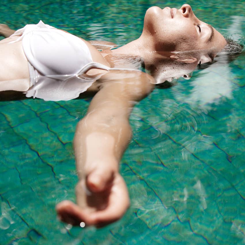 woman floating in water while in a swimming pool