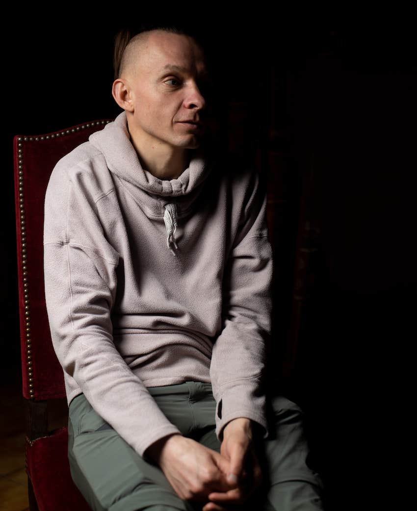 insecure man sits on a chair on a black background